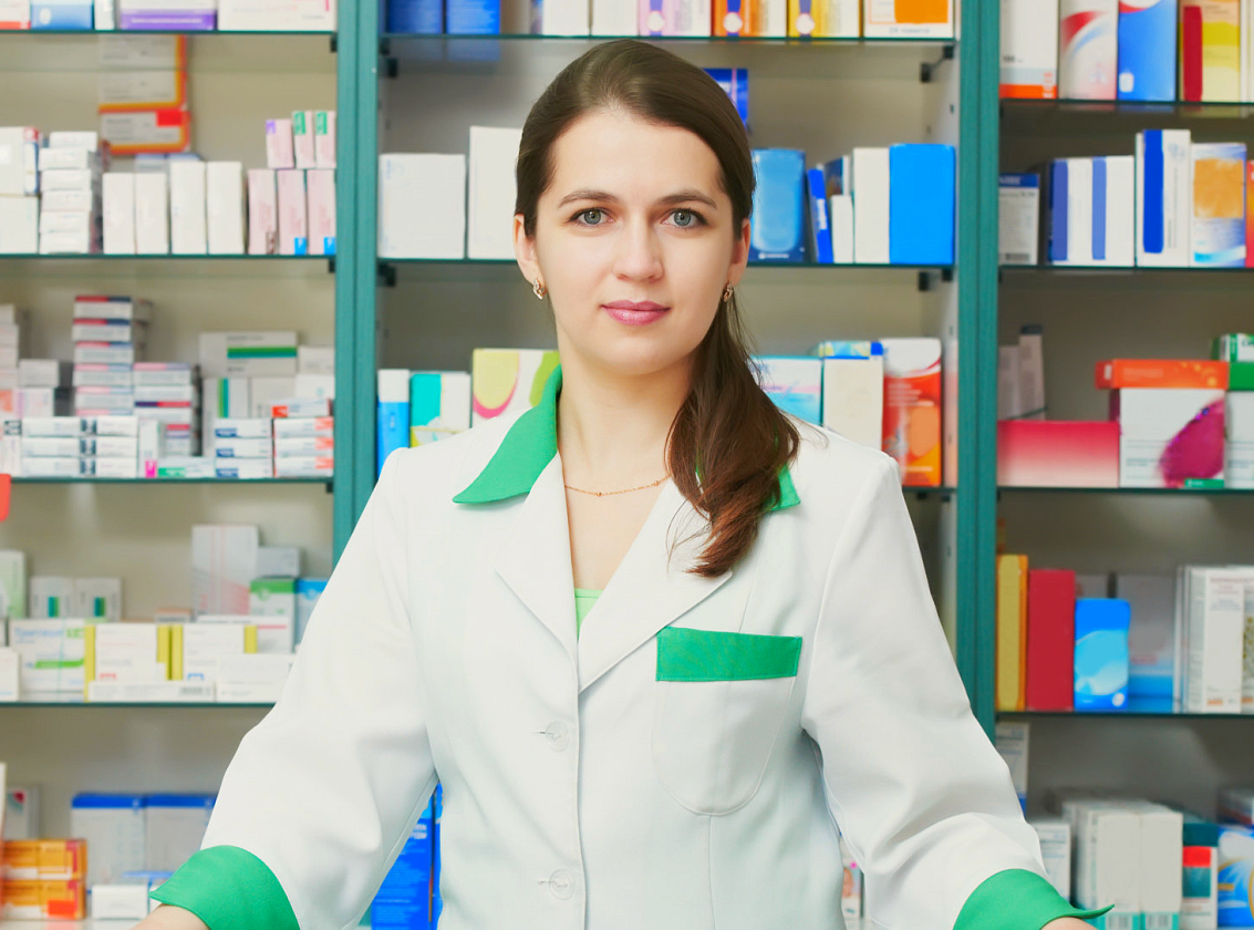 Cheerful pharmacist chemist woman standing in pharmacy drugstore