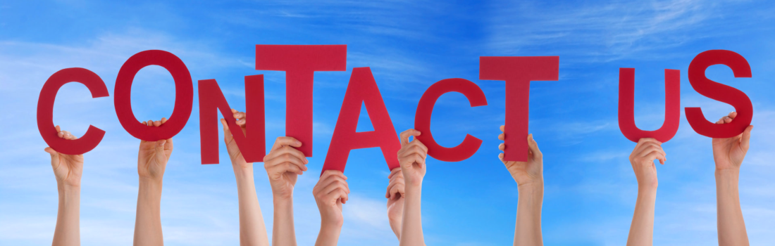 Hands holding contact us in front of the sky