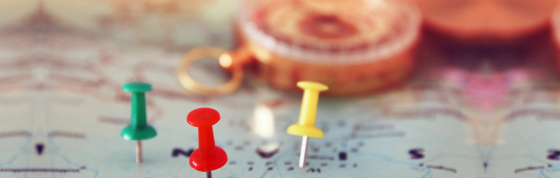 pins attached to map, showing location or travel destination and an old compass
